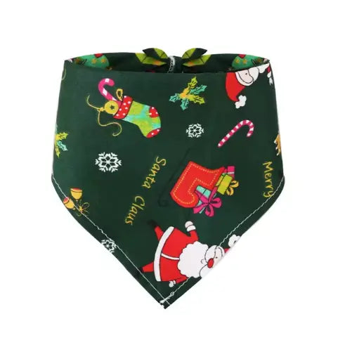 A dog wearing the green Santa-themed Christmas bandana with festive decorations in the background.